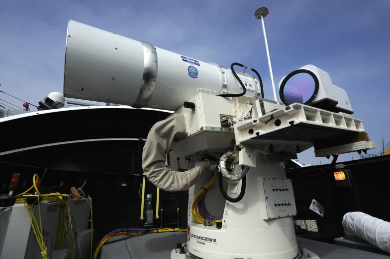 a man holding up a telescope on the back of a boat