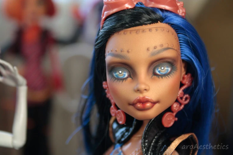 a closeup of a blue and black doll with eyeliners