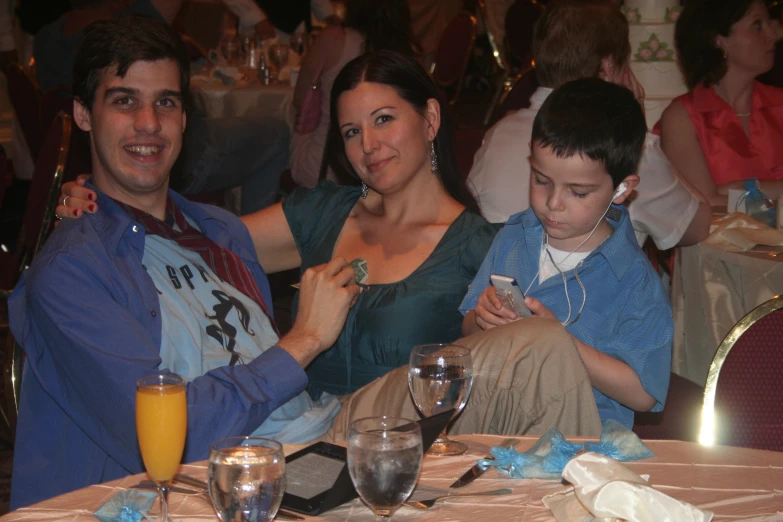 two people with their son sitting at a dining table