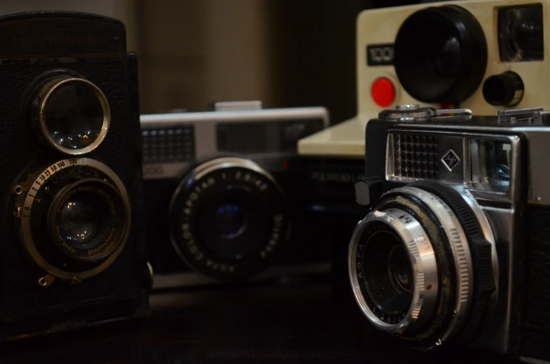 several vintage cameras sitting on top of a table