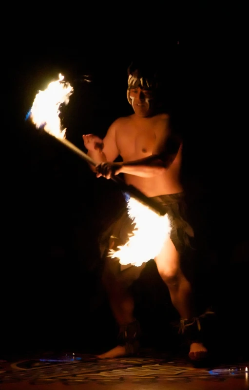 a man is holding fire torches in the dark