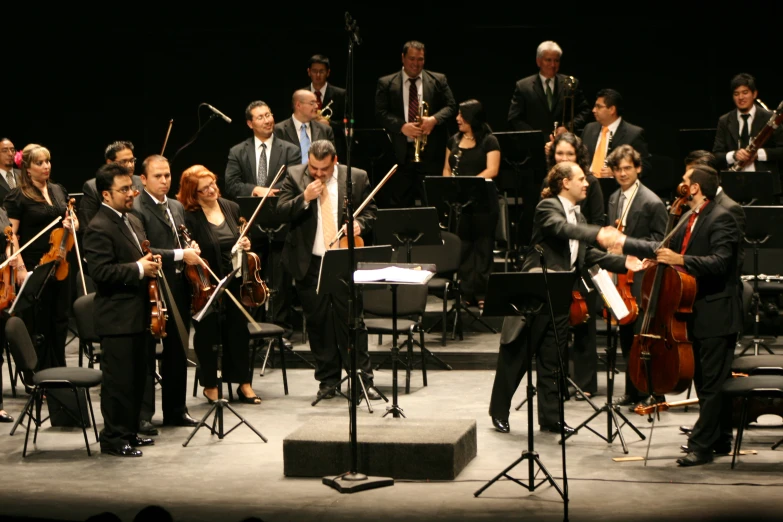 a group of men and women on stage playing musical instruments