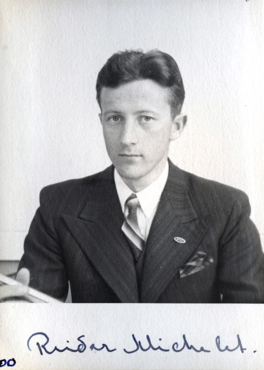 an old po shows the man sitting at a desk in a suit