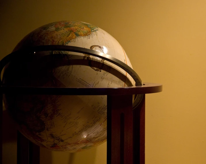 a small stand holding an old looking globe