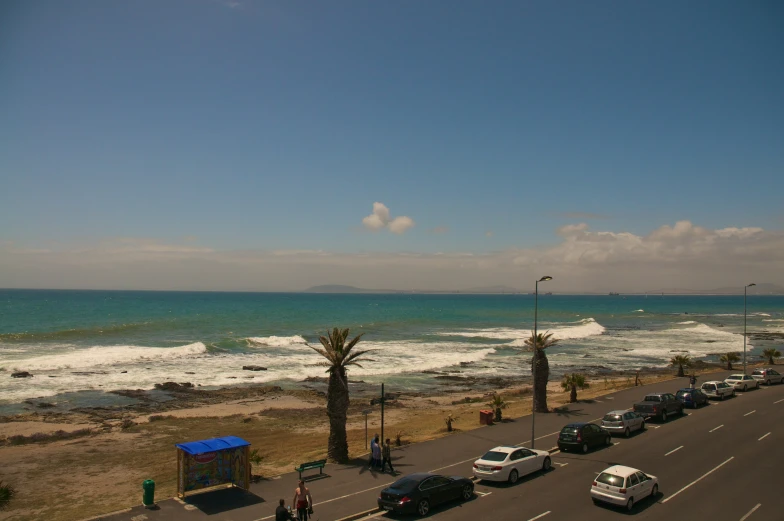 cars and trucks are on the road by the ocean