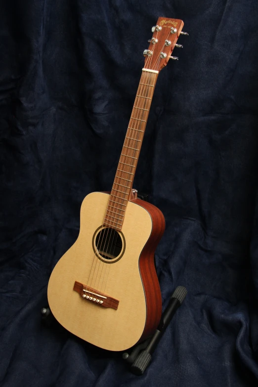 a wooden guitar is standing on a blue sheet