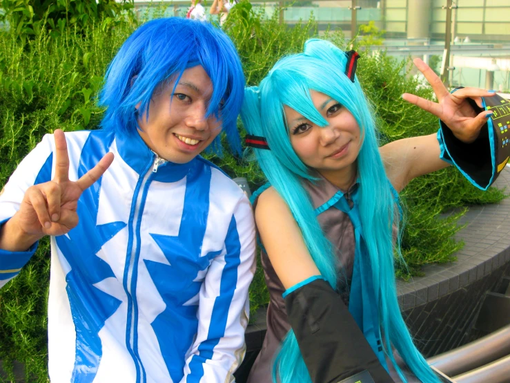 two people posing for a po with blue wigs and one is making the sign