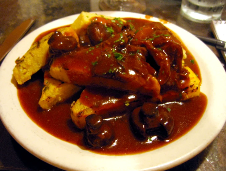 a plate of mashed potatoes topped with meat and gravy