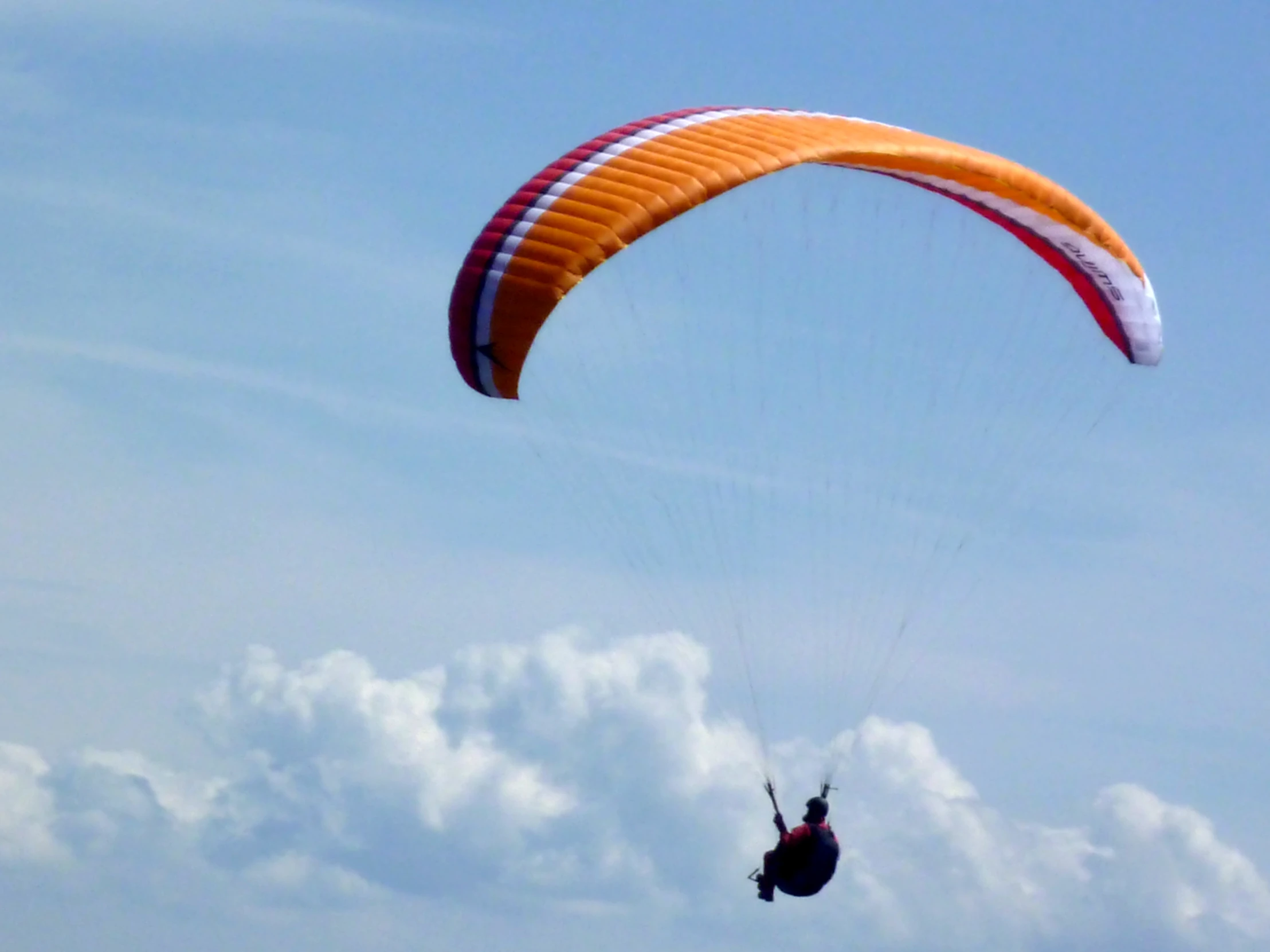 man riding a parachute in the sky on his feet