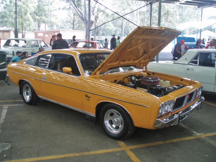 an orange mustang is parked in a parking lot