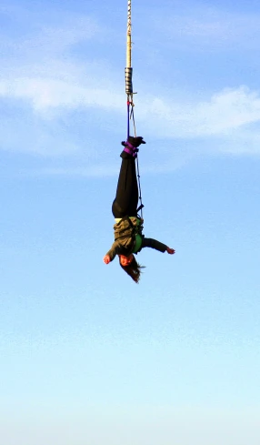 a person falling off a parachute high in the sky