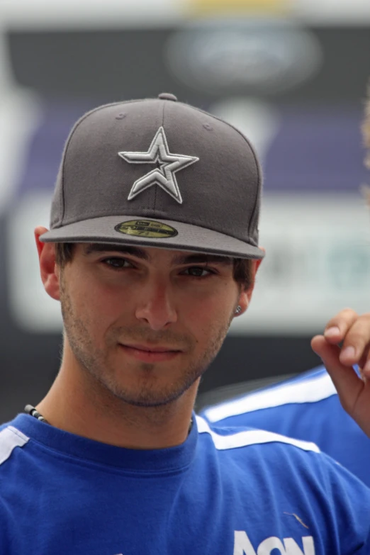 man in baseball cap posing for camera while wearing a baseball cap
