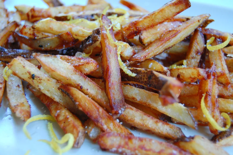 a plate filled with cooked fries and yellow strips