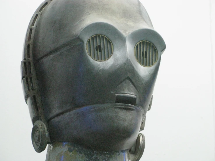 a person's head wearing a mechanical helmet with multiple oval eyes