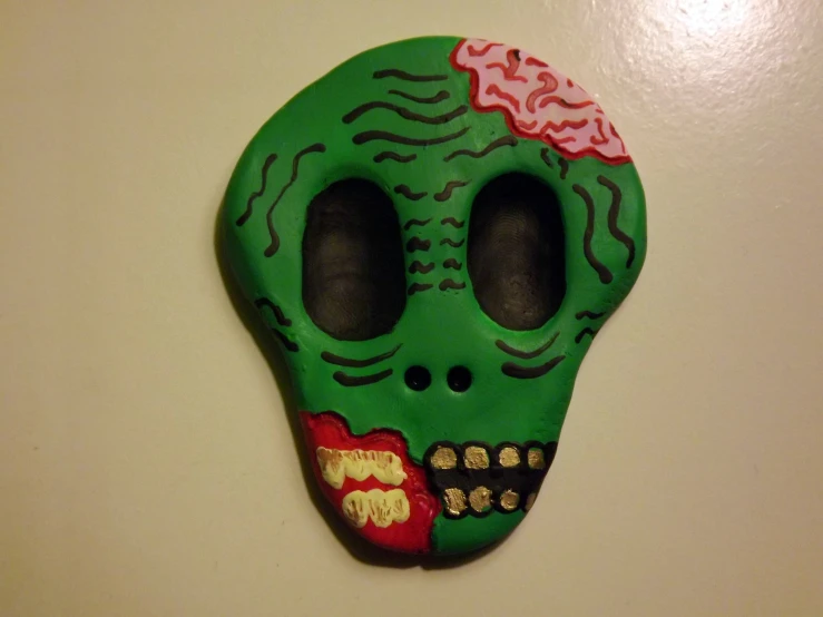 a green plastic skull with holes in the forehead