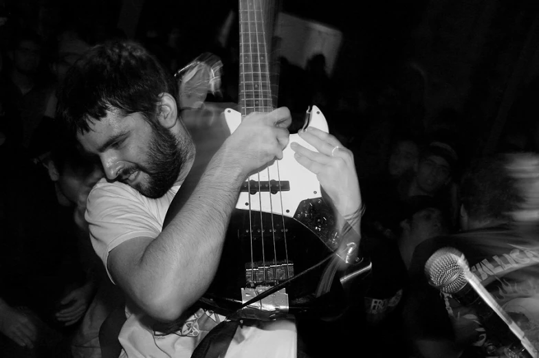 a man holding his neck around an acoustic guitar