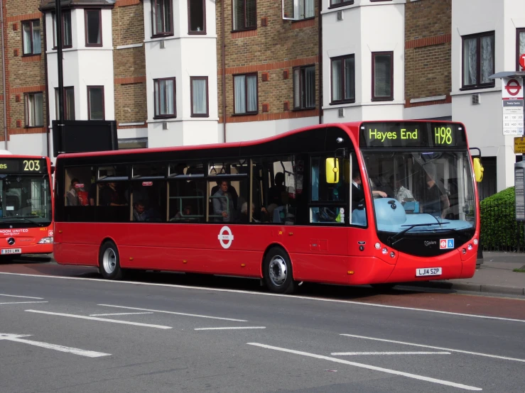 two red busses on the street next to each other