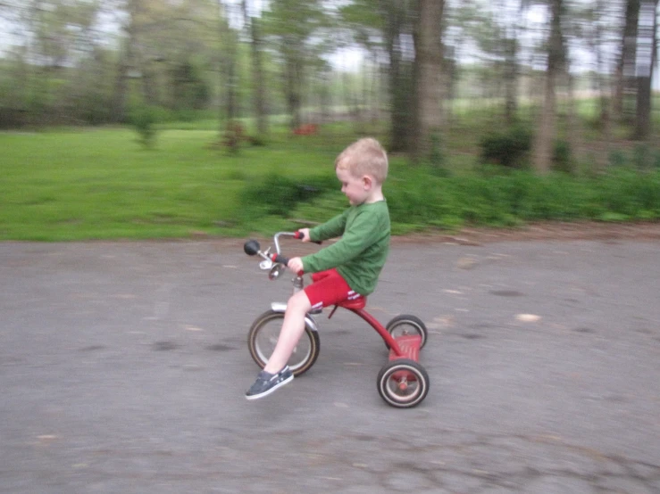 a small child riding on the front wheel of a bicycle