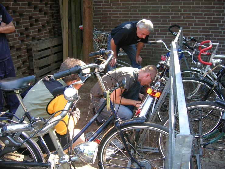 two people are inspecting a bicycle while one looks down at the bikes