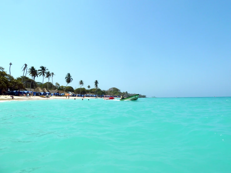 people on a beach with a boat in the ocean