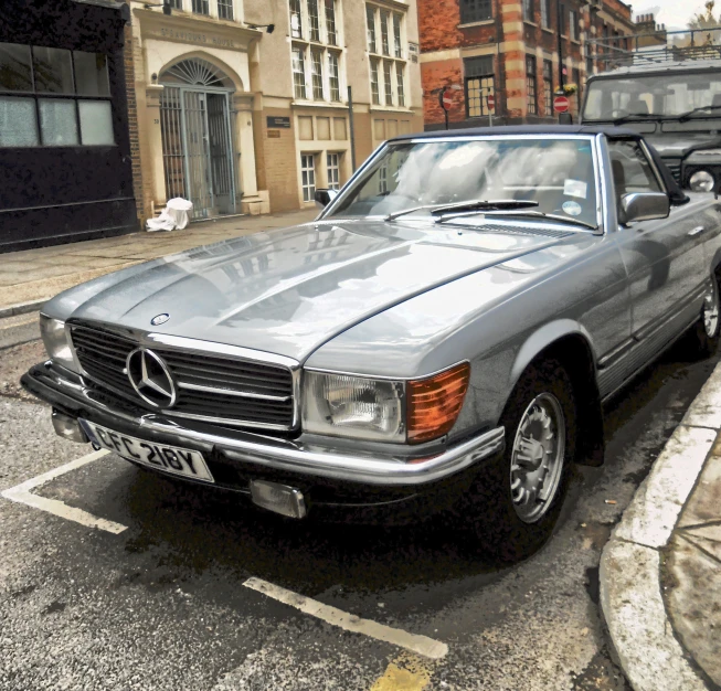 silver car parked on street next to building