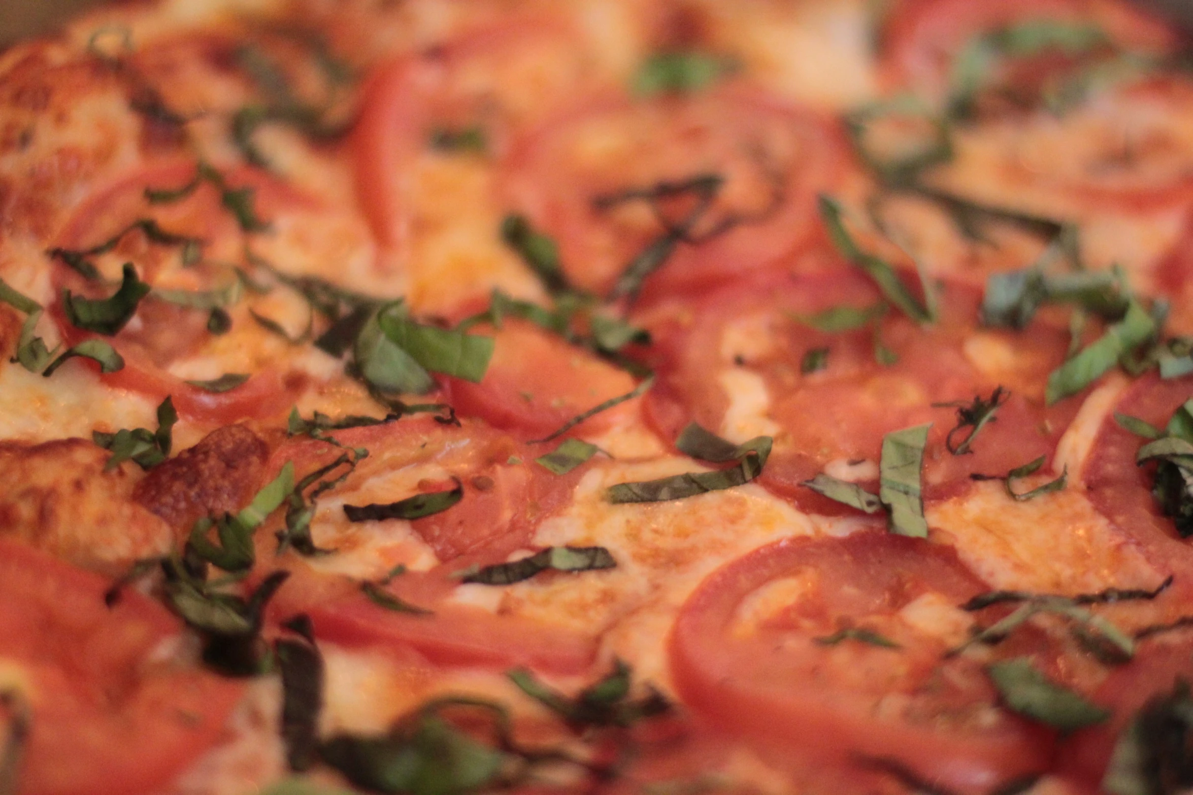 a pizza topped with tomatoes and herbs on top of it