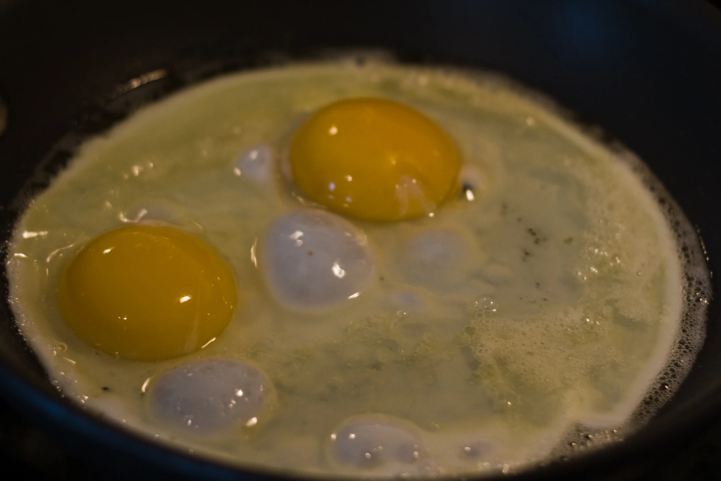 three eggs are being fried in a pan