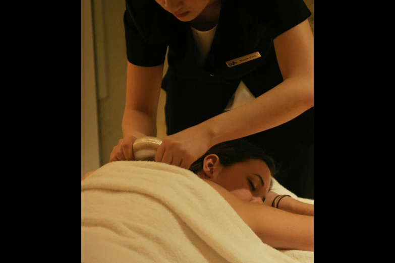 a woman getting a  stone massage from a female doctor