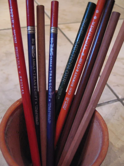 many pencils are in a brown ceramic container