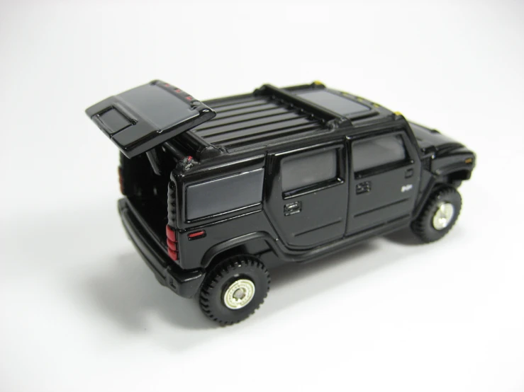 a toy car with black tires on white surface