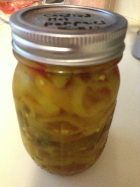 a jar filled with canned pickles sitting on a counter