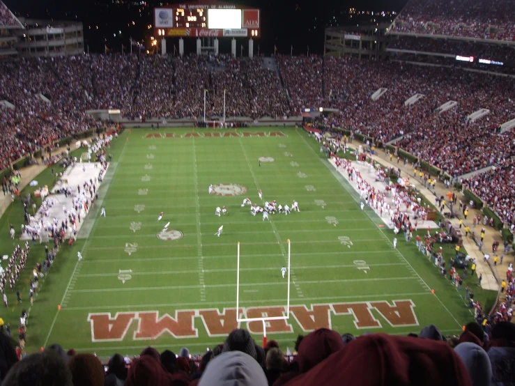 people are sitting in bleachers watching a football game