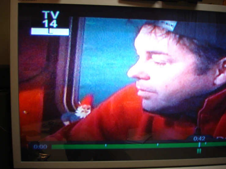 a man that is on tv with the cat in the corner