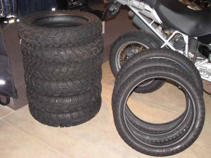 a motorcycle parked beside other motorcycle tires on the floor