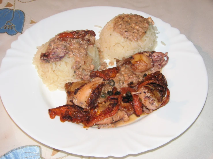 meat on a plate with gravy and white rice