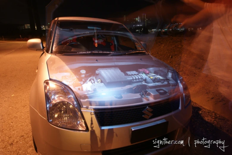 the front of a silver car with the engine bay open