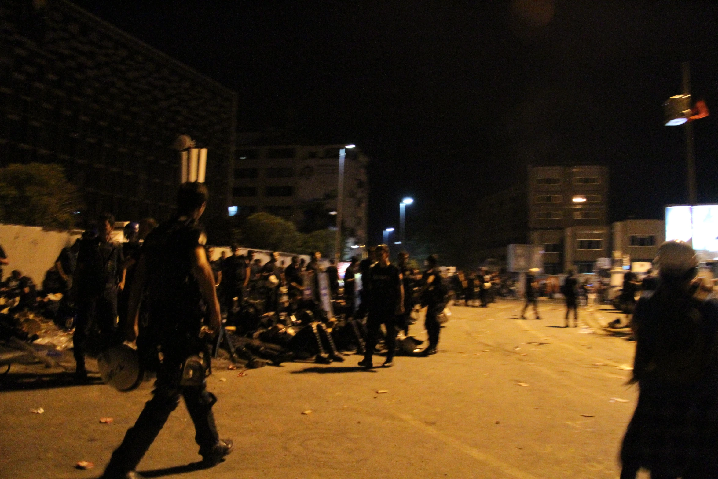 a large group of people standing in the street at night