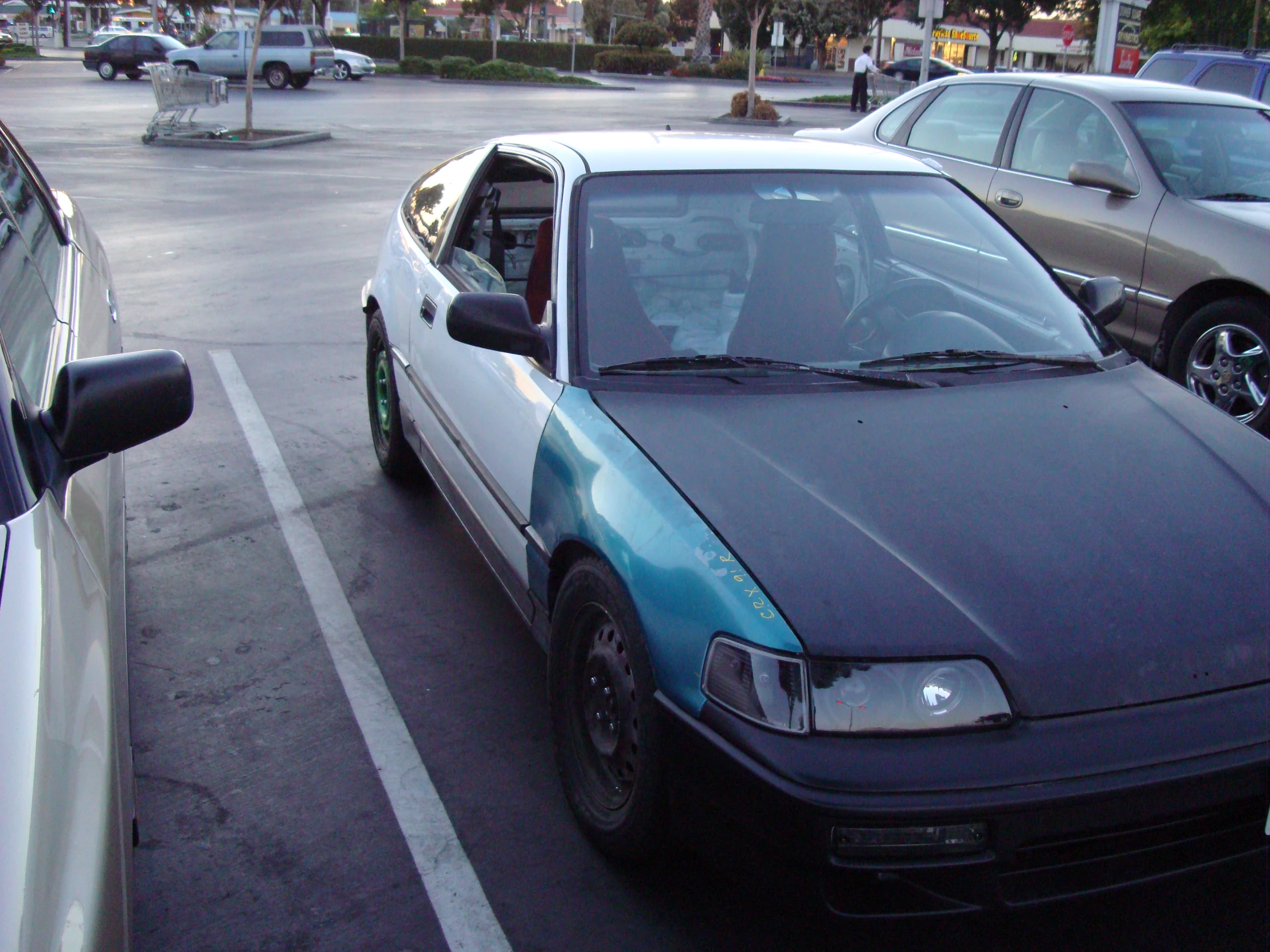 a blue car parked in the middle of a street