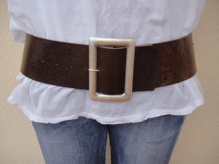 a belt with a metal buckle, jeans, and a white shirt