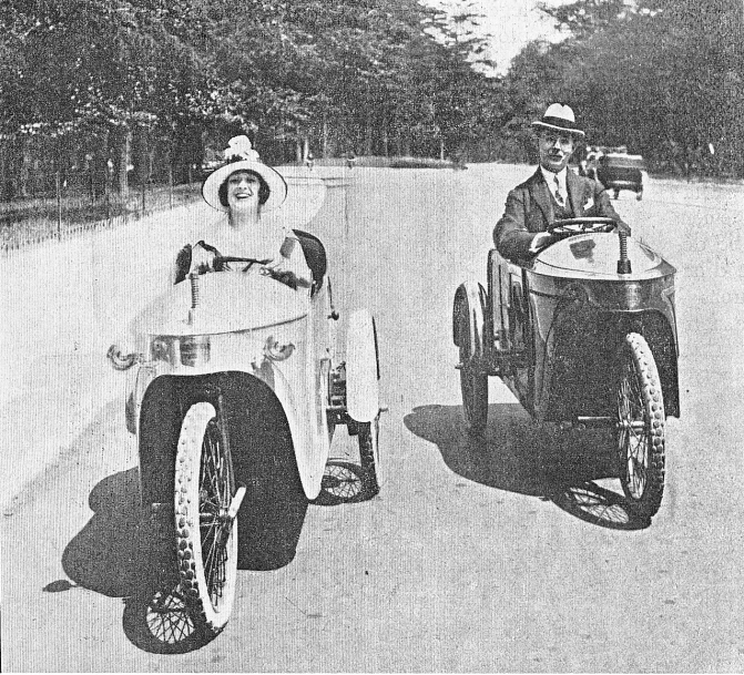 a man driving a buggy with two women in the front