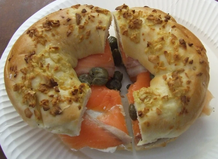 a paper plate with a bagel cut in half