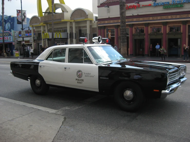 a black and white police car is parked on the street