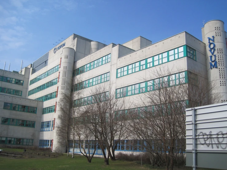 a building with some green windows next to trees