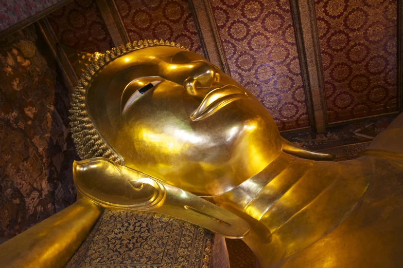 the inside of a golden buddha statue next to wallpaper