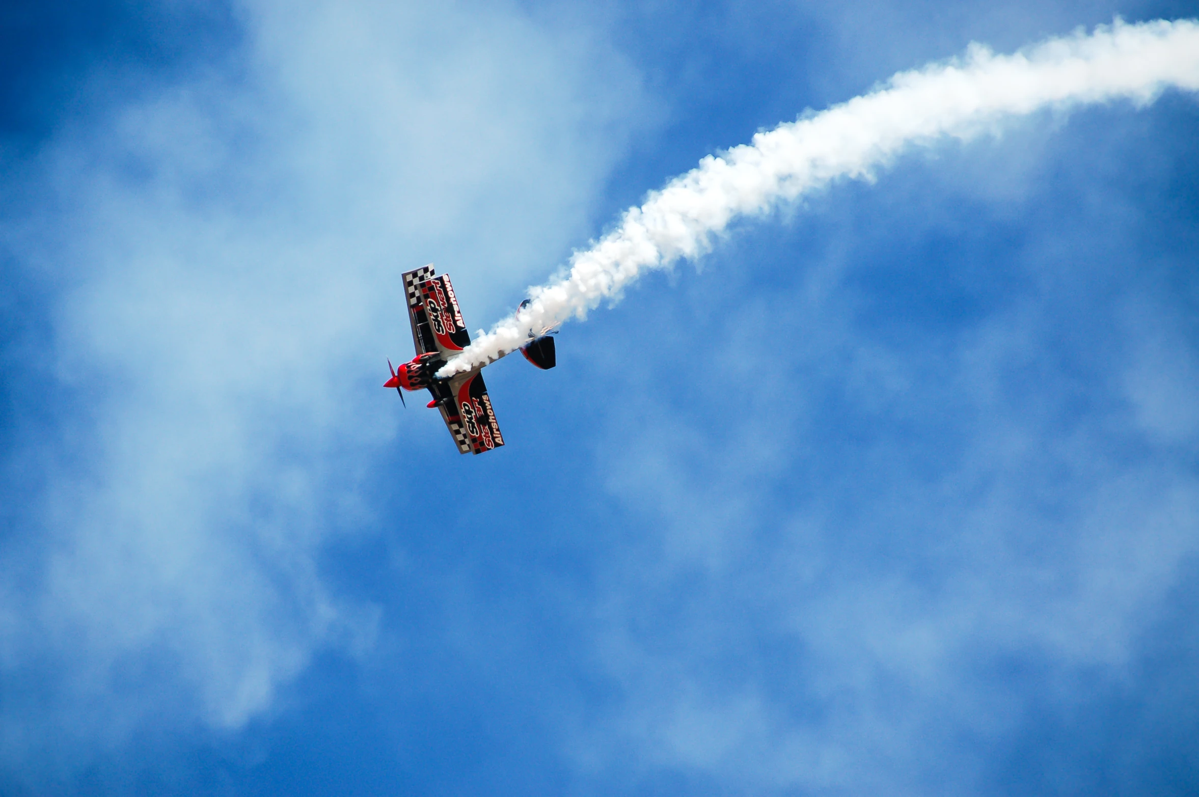 a small airplane with two smoke trails coming out of it