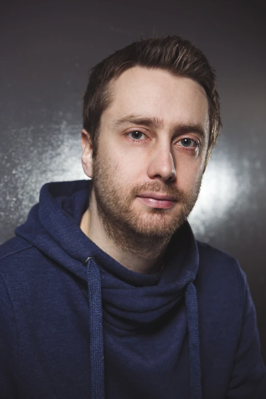 a male in a blue shirt with a beard