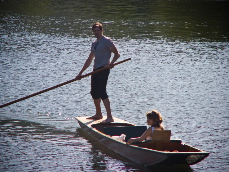 two people floating in a boat with one paddle