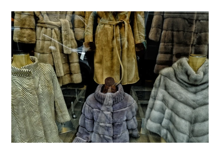 various coats and jackets in display behind glass