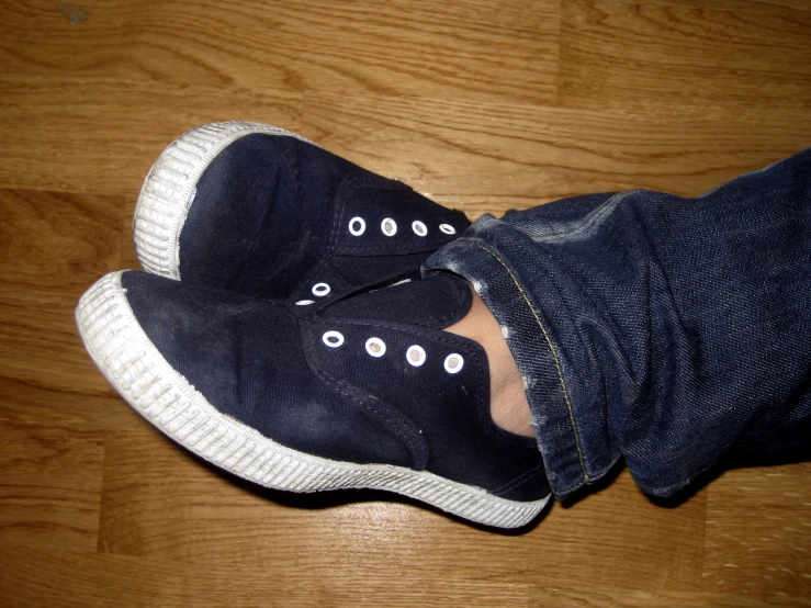a persons foot with an on wearing sneakers