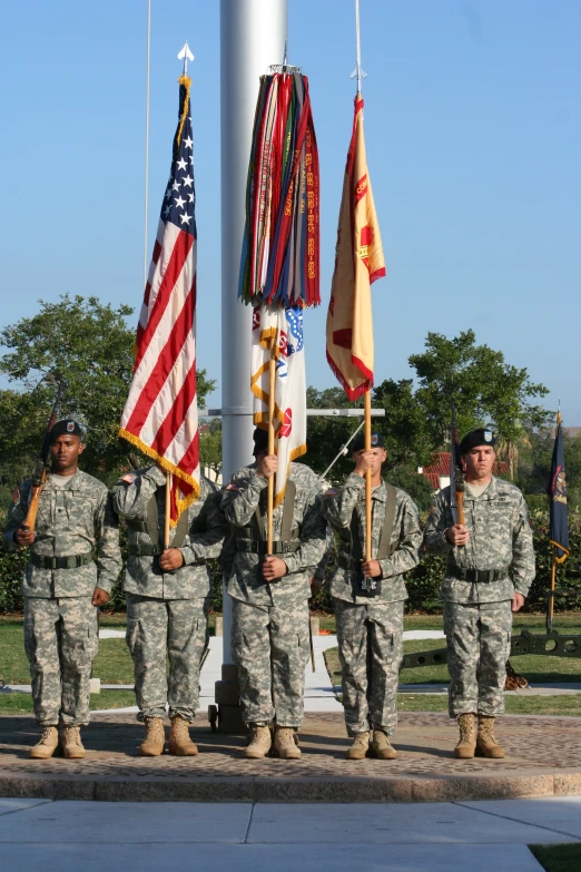 a group of soldiers standing next to two flags